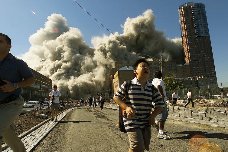 In lower Manhattan near Ground Zero, people run away as the North Tower of the World Trade Center collapses.