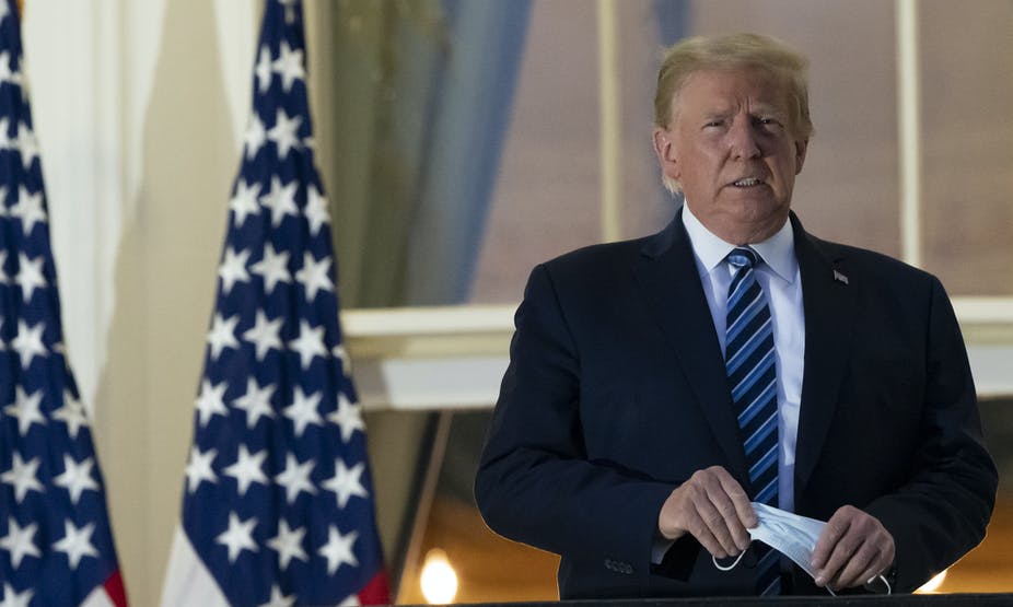 President Trump holds a mask on his return from Walter Reed Medical Center on Oct. 5, 2020.