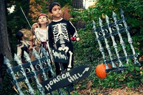 Some pumpkins and hand-painted signs combined with an antiqued fence make for a pretty spooky haunted trail.