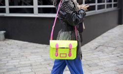 Ahead of the trends: A woman carries a Cambridge satchel in neon at London Fashion Week 2012.