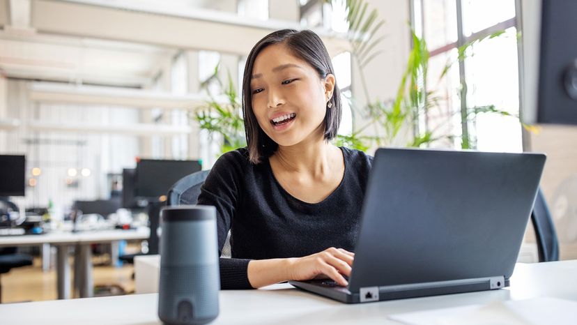 woman looking at Alexa and computer